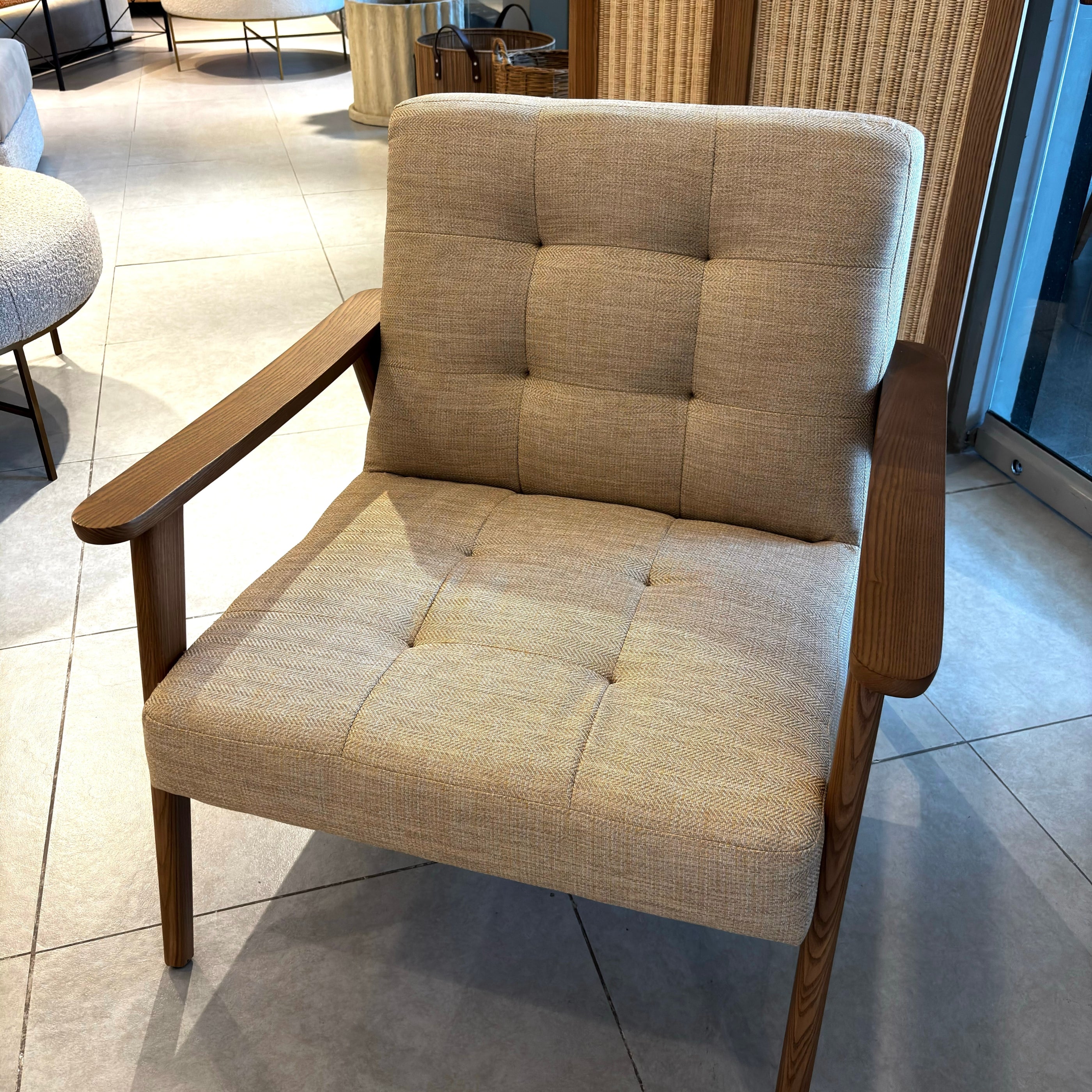Beige armchair with wooden frame on a tiled floor